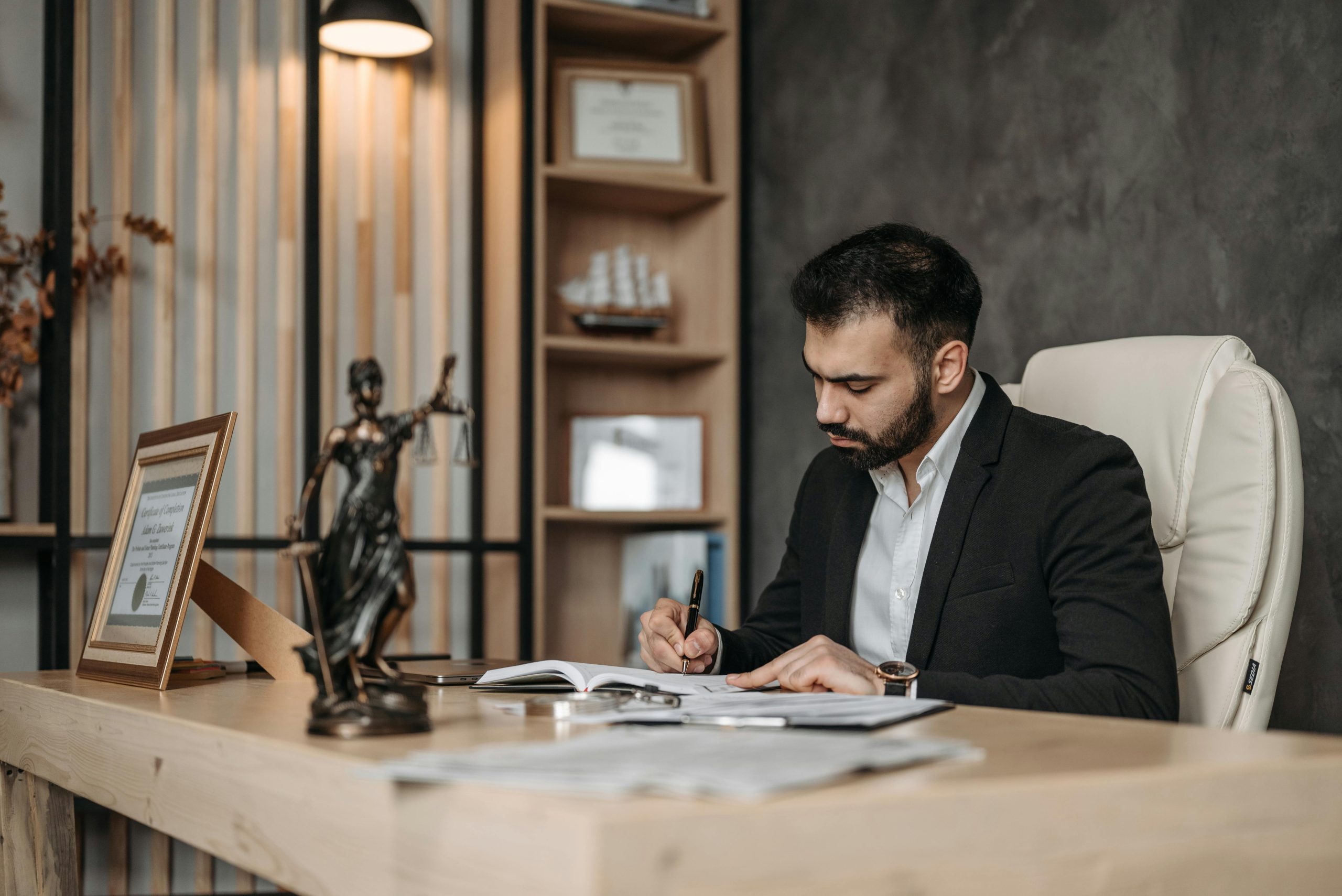 Lawyer writing information down at a desk.