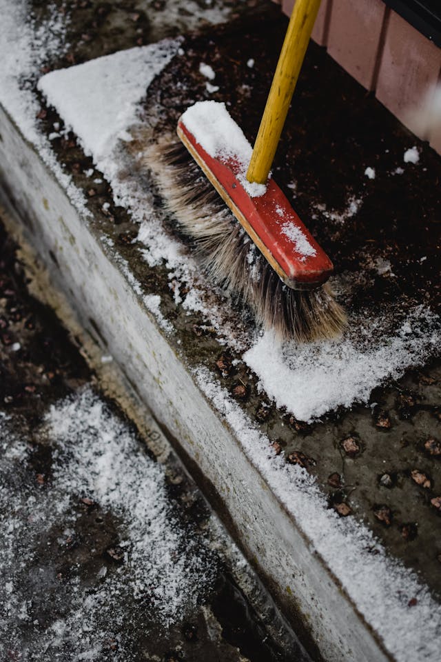 broom sweeping snow off steps